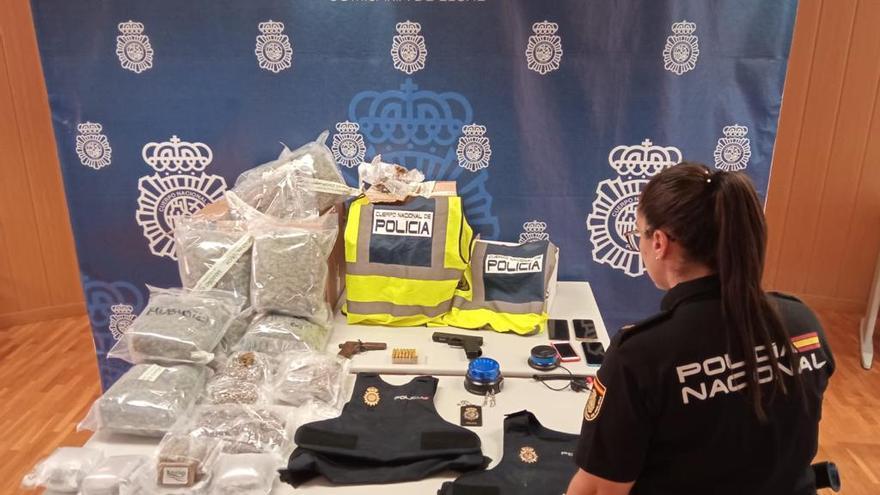 Una policía nacional junto al material incautado a la banda que robaba droga a otros grupos criminales.