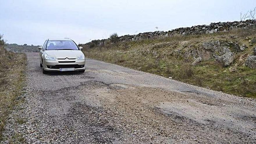 Un vehículo circula por el deficiente camino rural que une Carbajosa y Pino del Oro.