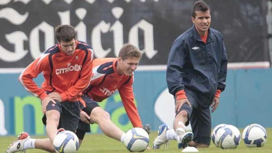 Danilo, a la derecha, estira sus músculos junto a Renan, centro,y Dani Abalo, al final del entrenamiento de ayer en A Madroa.