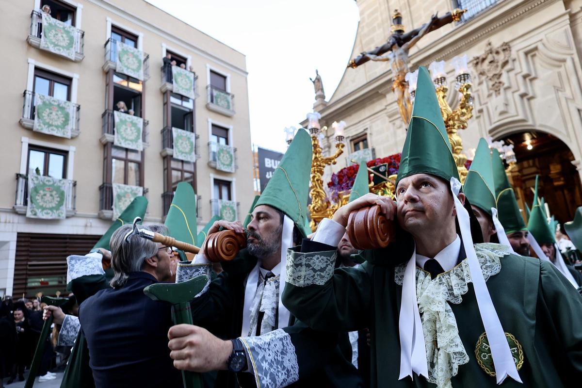 Los nazarenos cargando a hombros al Cristo de la Esperanza a la salida de la iglesia.