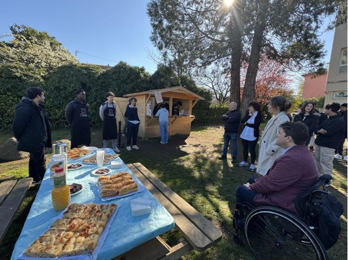 Representants del centre, alumnes i assistents a la visita, davant la guingueta d’esmorzars