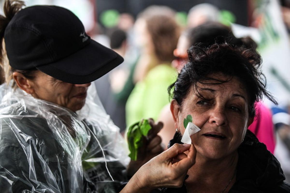 Una dona estampa un cor verd sobre una manifestatnt, a la platja d’Ipanema, durant la marxa contra contra el canvi climàtic.