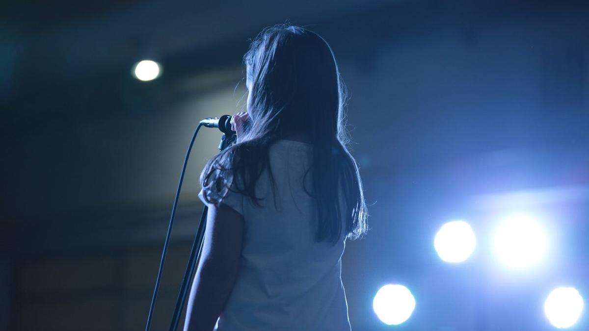 Una niña cantando sobre el escenario