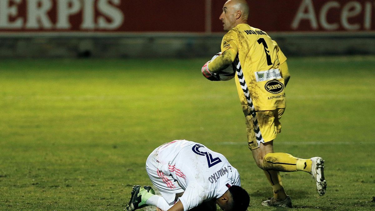 El portero del Alcoyano José Juan, durante el partido de Copa ante el Real Madrid con Militao sobre el césped.