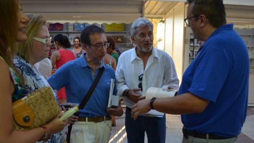 Tomás Sánchez (en el centro) y autoridades locales con un librero de la Feria del Libro.