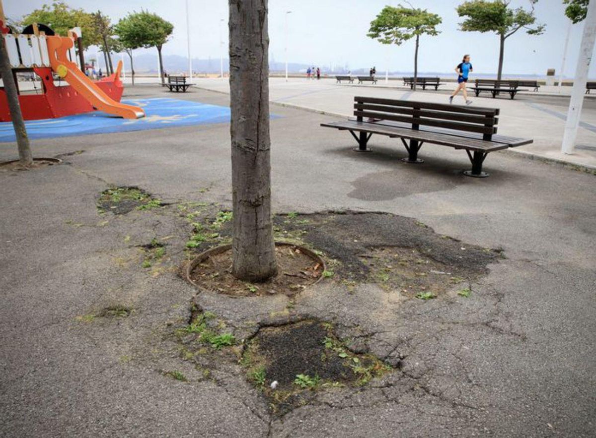 César Lete, señalando algunas de las tiras de pizarra rotas del paseo de Poniente.