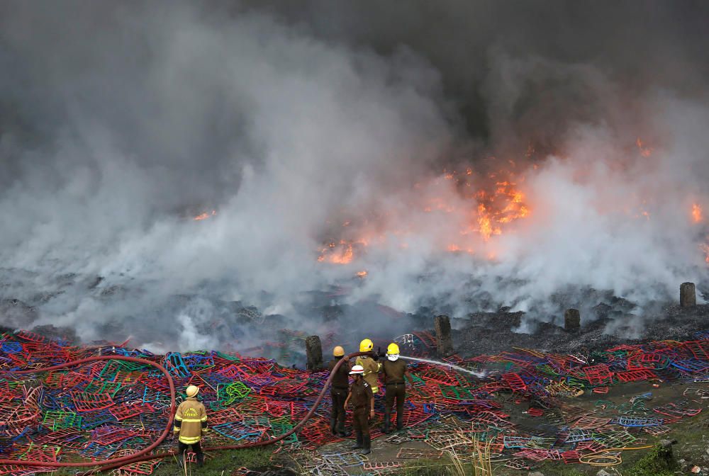 Firefighters try to douse a fire that broke out ...