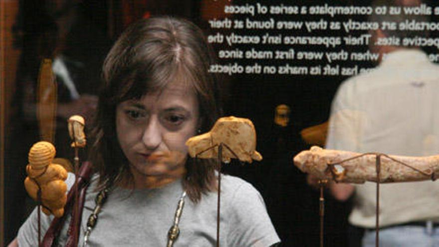 Una mujer observa algunas de las piezas que se exponen en la muestra del «Antiguo Instituto» sobre Atapuerca