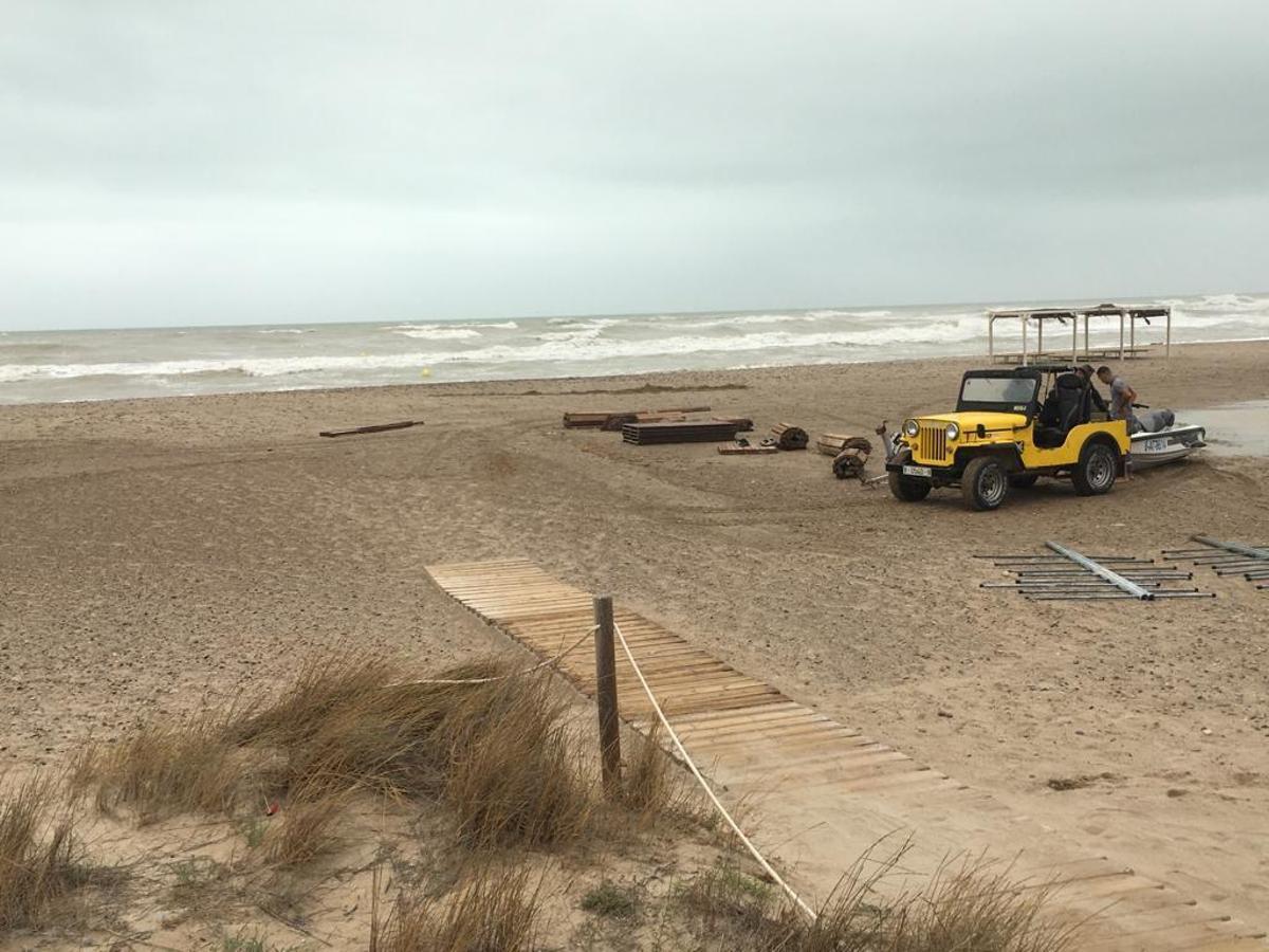 Momento del desmontaje del servicio de hamacas y sombrillas, en Canet.