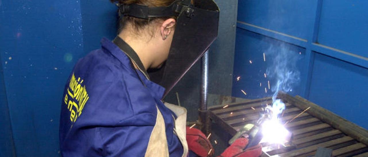 Una alumna de un curso de formación en el sector del metal realiza una soldadura.