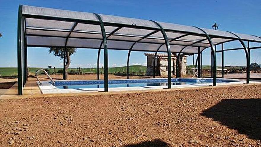 Piscina del Hotel Rural Teso la Encina cubierta con la cúpula de metacrilato y restaurante del establecimiento en Villamor de los Escuderos.