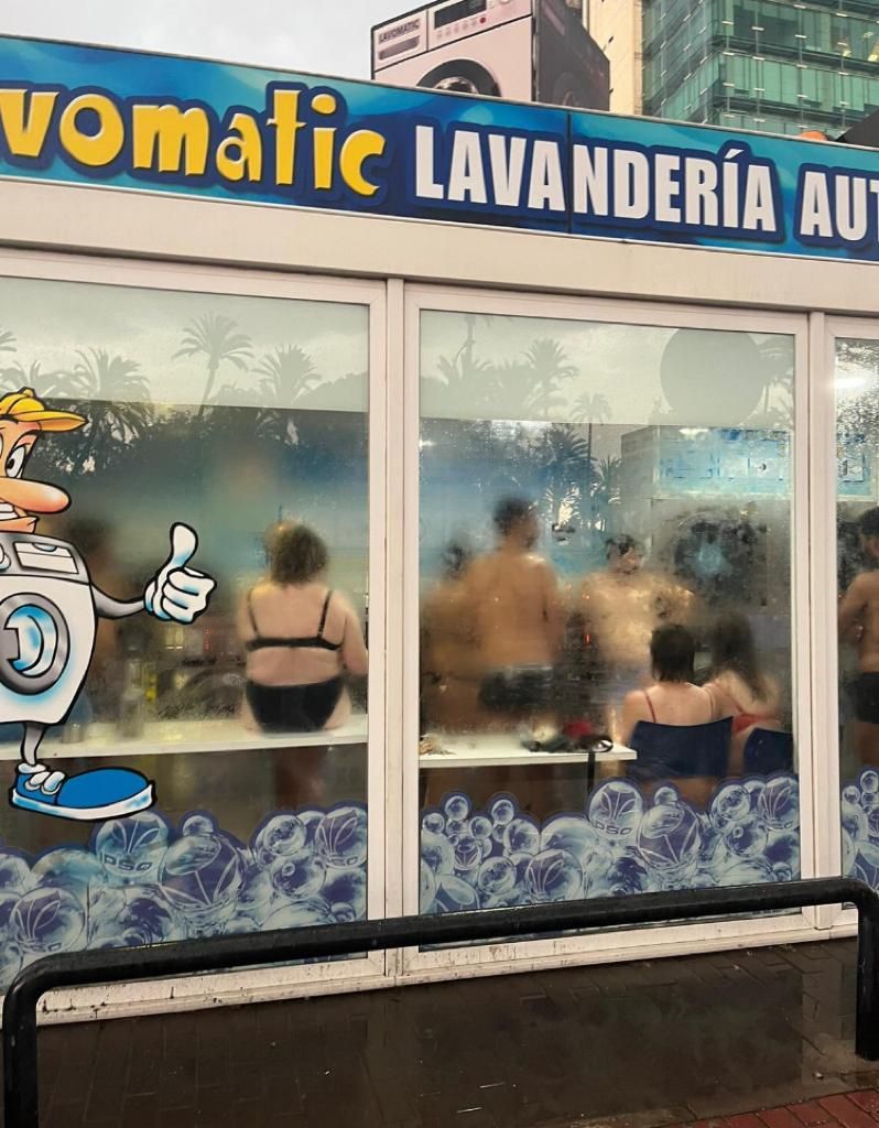 Asistentes al Warm Up se refugian en una lavandería y aprovechan para secar la ropa.