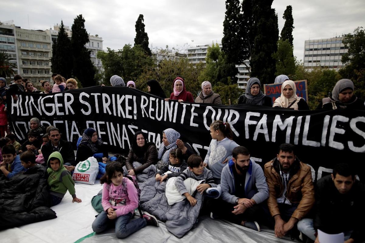 Refugees seeking reunification with family members in Germany sit in front of a banner announcing a hunger strike during a protest near the parliament building in Athens  Greece  November 1  2017  REUTERS Alkis Konstantinidis