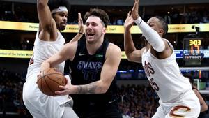 Luka Doncic, de los Dallas Mavericks, en una acción ante Jarrett Allen y  Isaac Okoro de los Cleveland Cavaliers