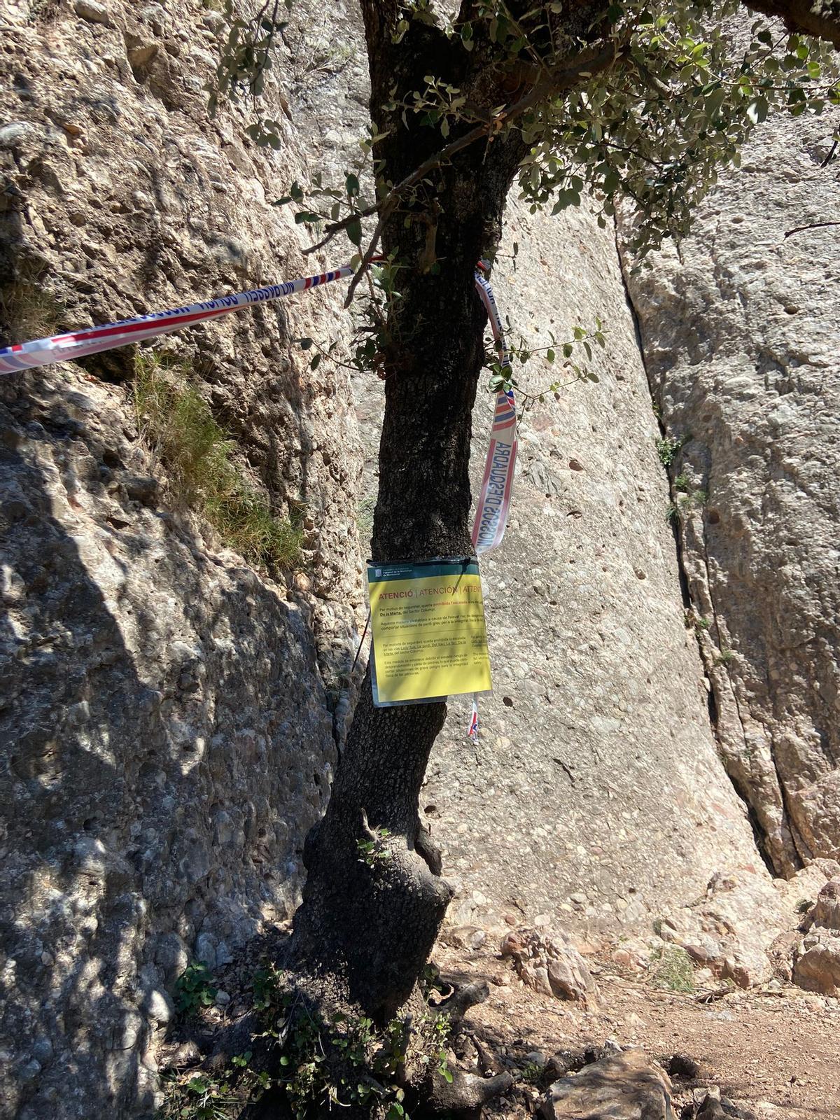 Cinta dels Mossos i el cartell del Patronat de la Muntanya indicant que no es pot practicar escalada a la zona