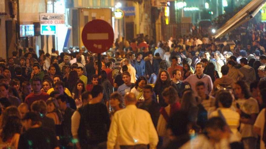 Una de las calles del Orzán, repleta de personas, por la noche.