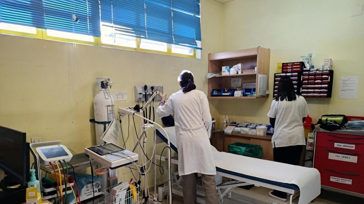 Dos enfermeras, preparando una sala de consulta.