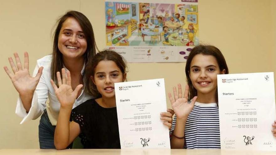 Patricia Rodríguez, con Irene y Victoria Pampillón, que muestran sus diplomas de Cambridge.  // J. Lores