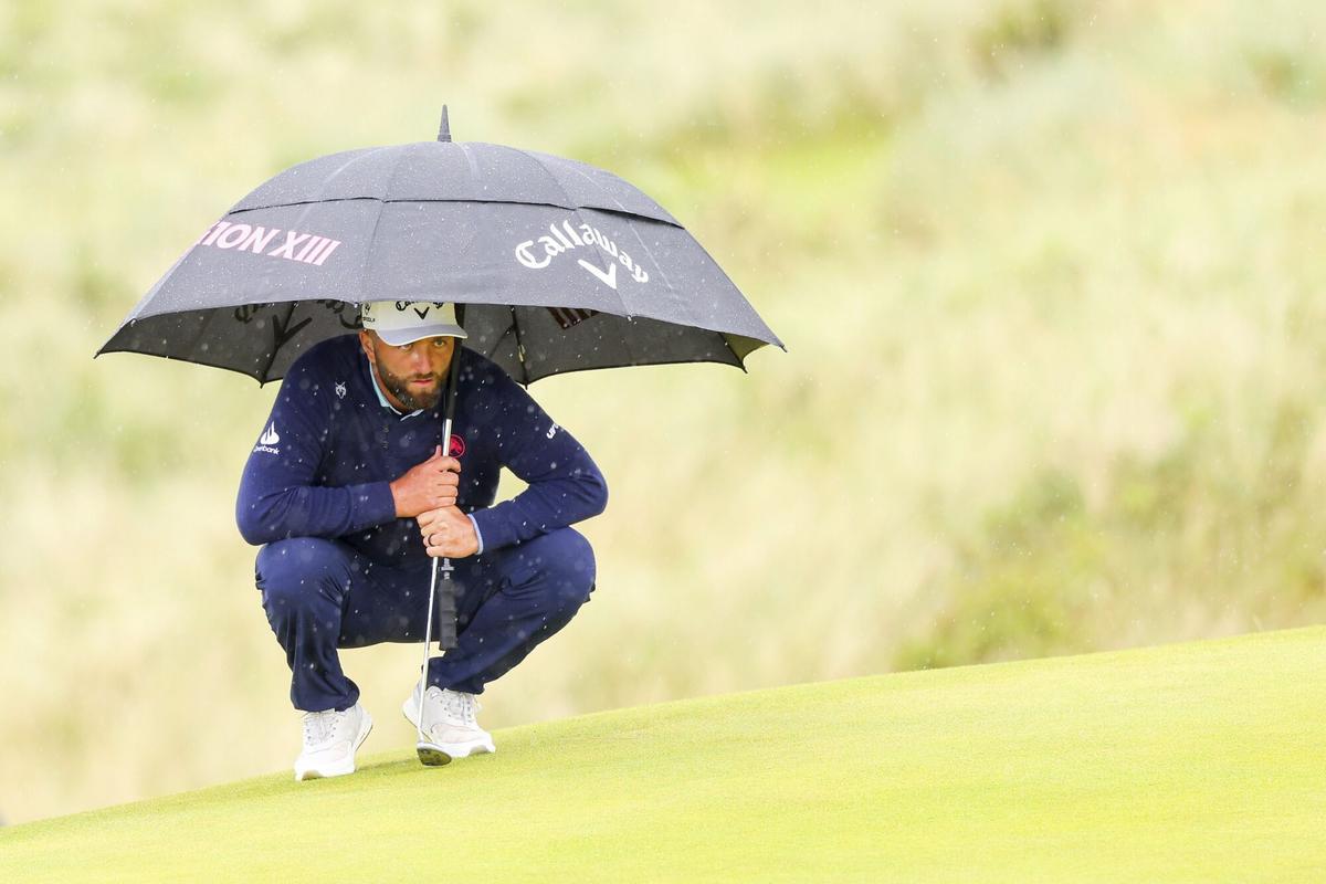 Jon Rahm estudia un putt bajo la lluvia en Royal Portrush