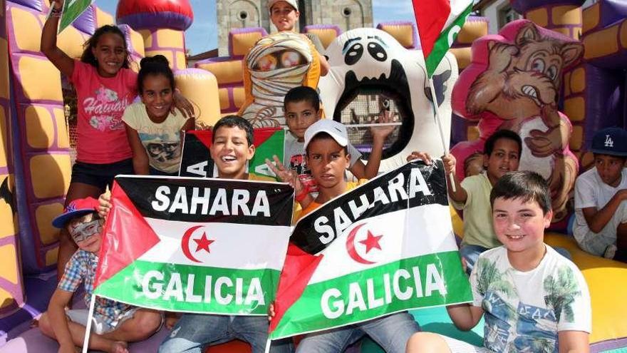 Varios niños asistentes a la jornada de convivencia posan con las banderas en que se hermanan las patrias de Sáhara y Galicia. // Bernabé/Luismy