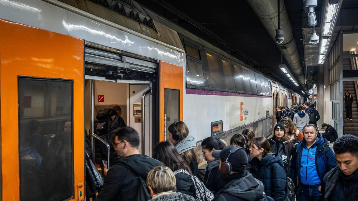 Usuaris de Rodalies pujant a un tren.