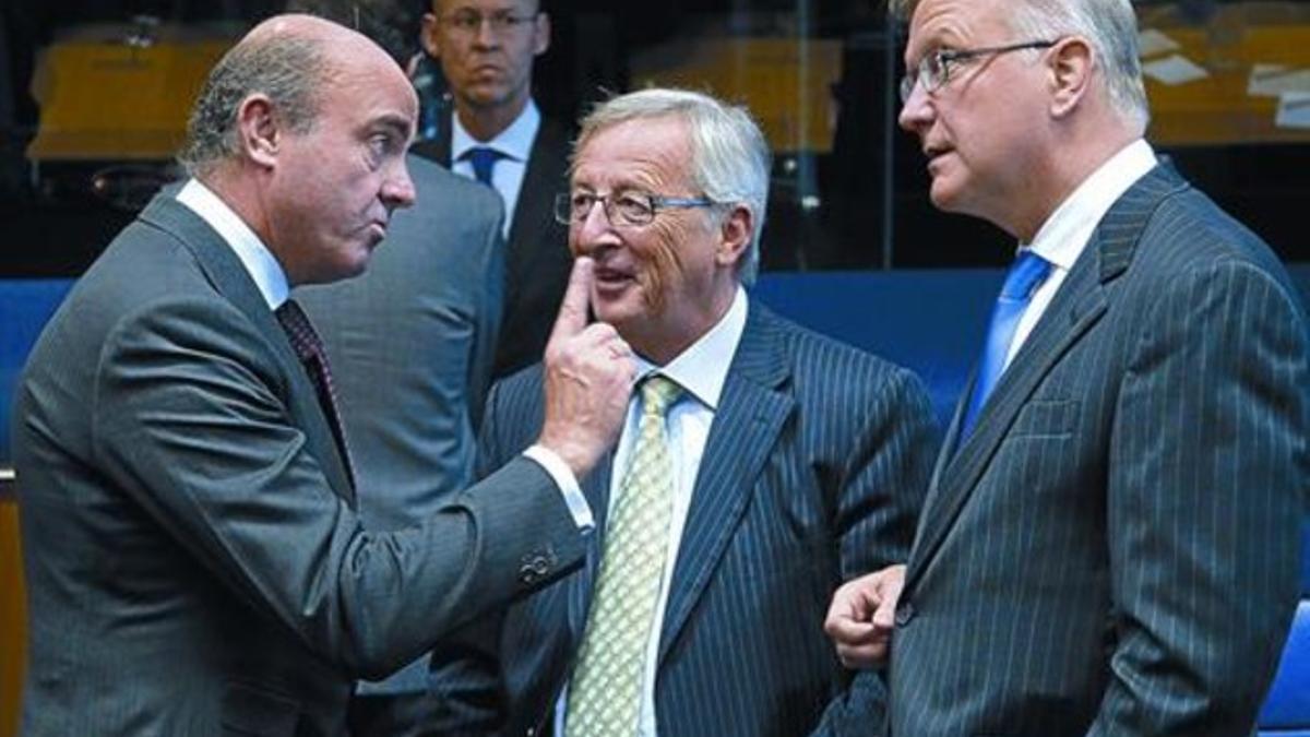 Luis de Guindos conversa con el presidente del Eurogrupo, Jean-Claude Juncker, y el comisario europeo Olli Rehn, ayer.