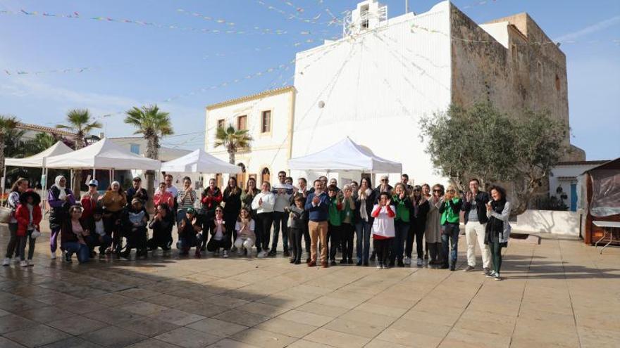 Los voluntarios posan en la plaza de la Constitució.