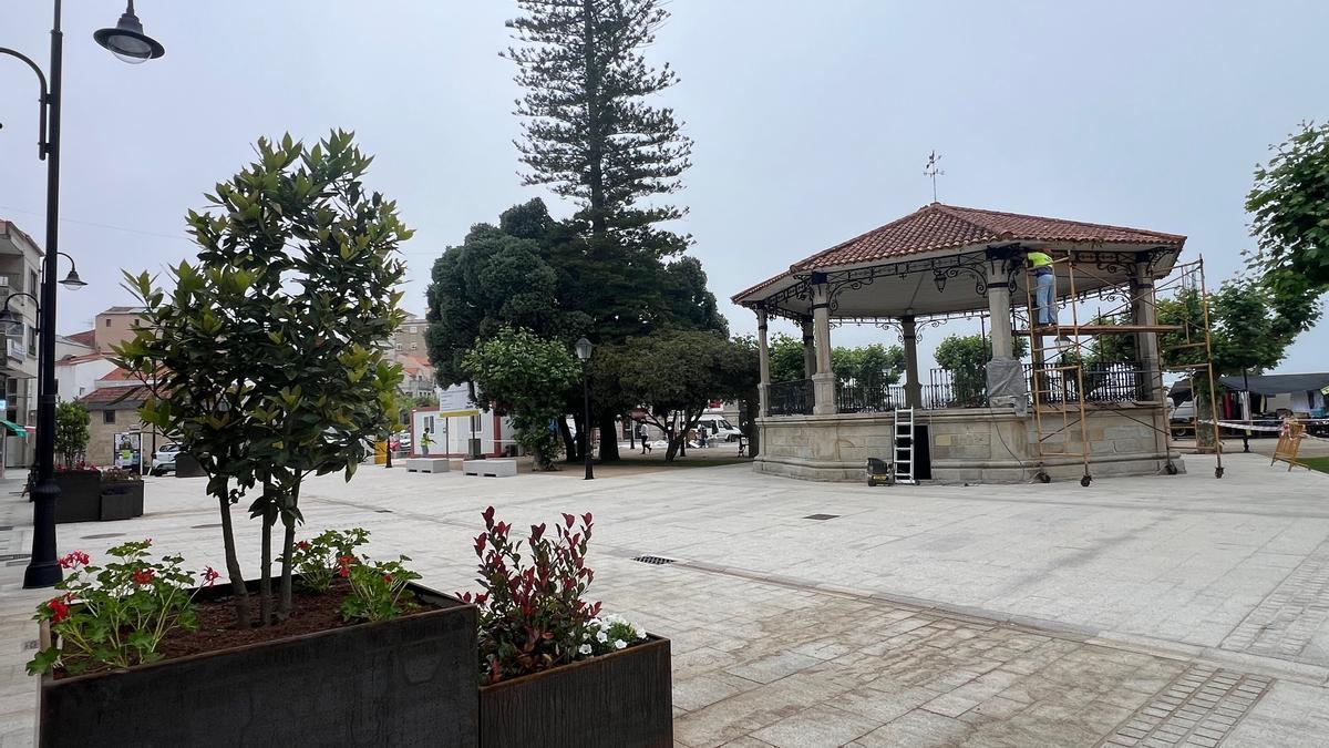 Trabajadores de la empresa adjudicataria, dando los últimos retoques a la alameda y el palco de la música, ayer.