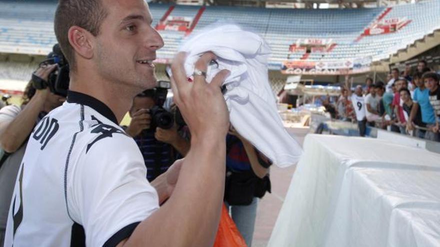 El nuevo delantero del Valencia CF para las cuatro próximas temporadas, Roberto Soldado, saluda al público durante su presentación oficial este mediodía en el estadio de Mestalla.