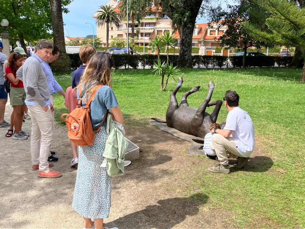 Turistas junto a la escultura del burro.
