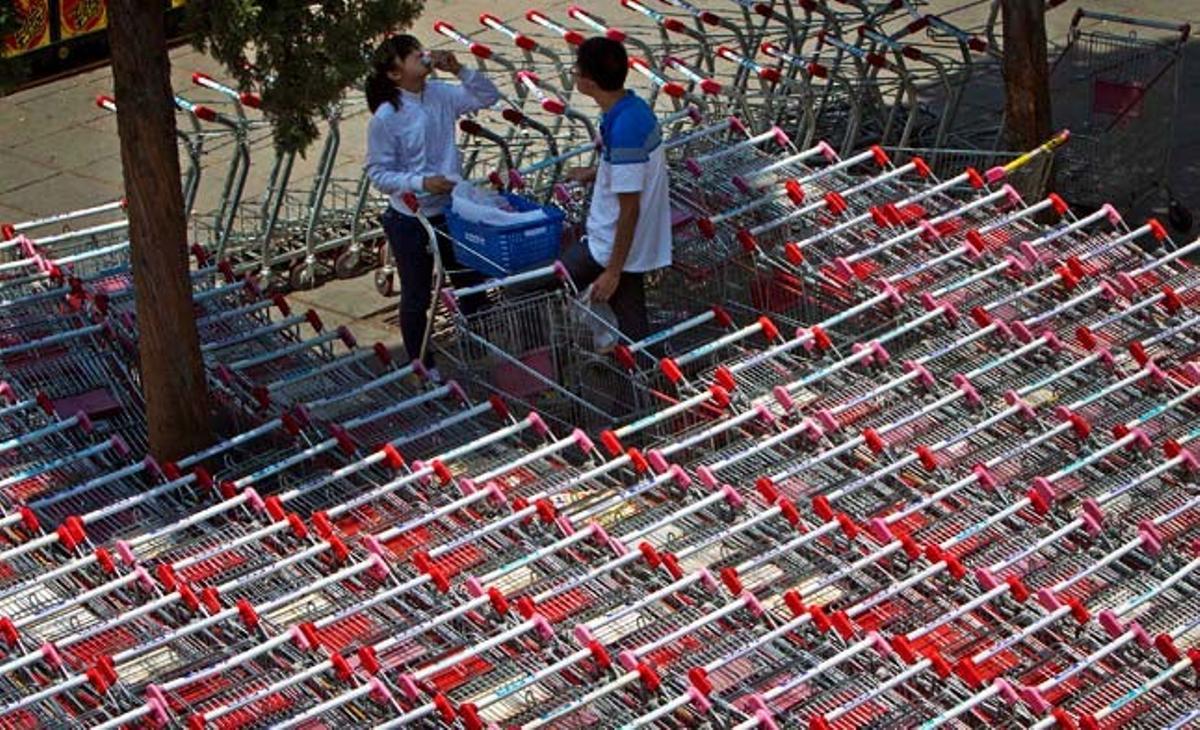 Una parella de joves dinen sota una ombra a l’exterior d’un hipermercat a Pequín (Xina).