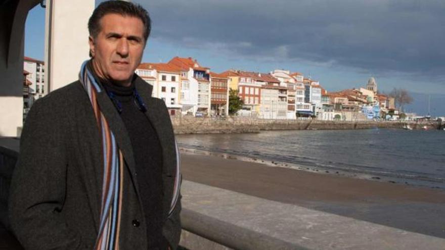 Cuco Fernández Fernández posa con la fachada marítima de Luanco a sus espaldas.