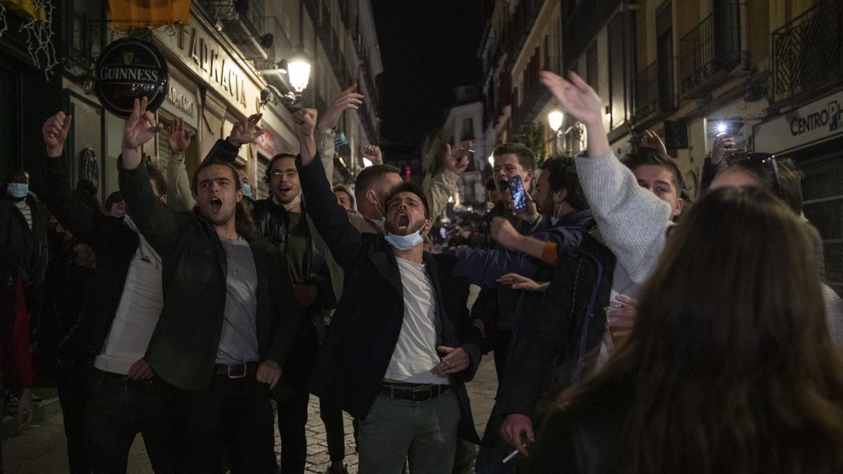 Turistas franceses cantan animados a las puertas de un bar de Madrid.