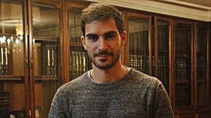 El joven Adrián Posado, de 31 años, posa junto a su tesis doctoral.