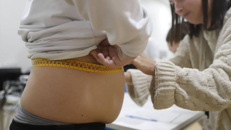 Una pediatra mide el perímetro abdominal de un niño. | A. J. González