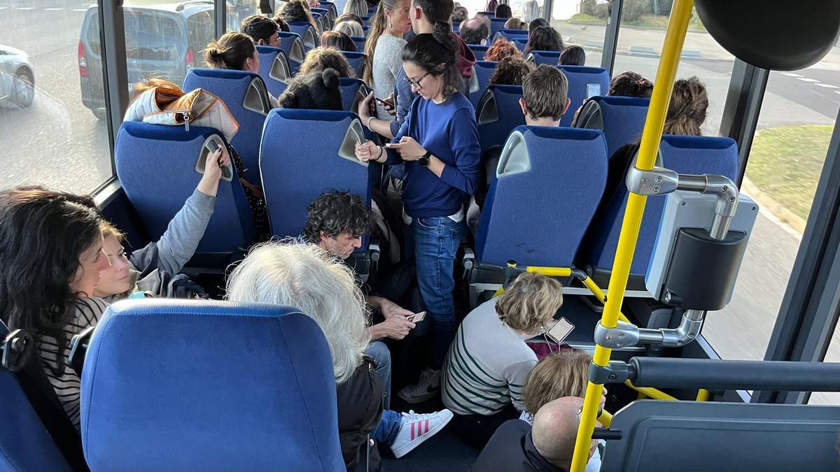 Gent dreta i asseguda al terra d’un bus en el trajecte de Barcelona a Manresa