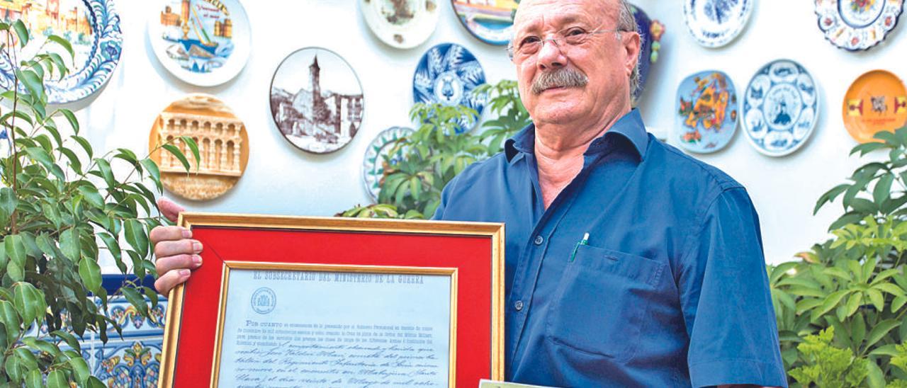 José Baldoví sostiene la foto del regimiento de cornetas donde estaba su abuelo y la carta de aprobación de las condecoraciones. G. Caballero