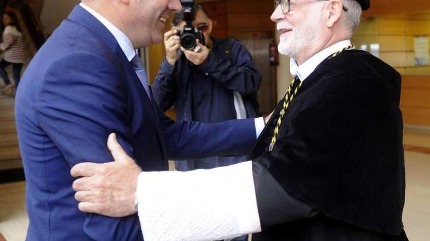 El conselleiro Román Rodríguez y el rector de la UDC, Xosé Luís Armesto, se saludan en el Rectorado.