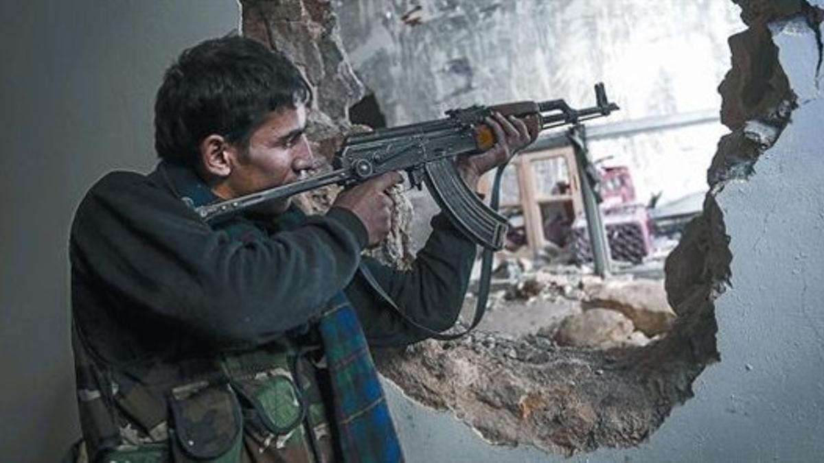 Un francotirador rebelde apunta a una posición de las tropas del régimen en Alepo, ayer.