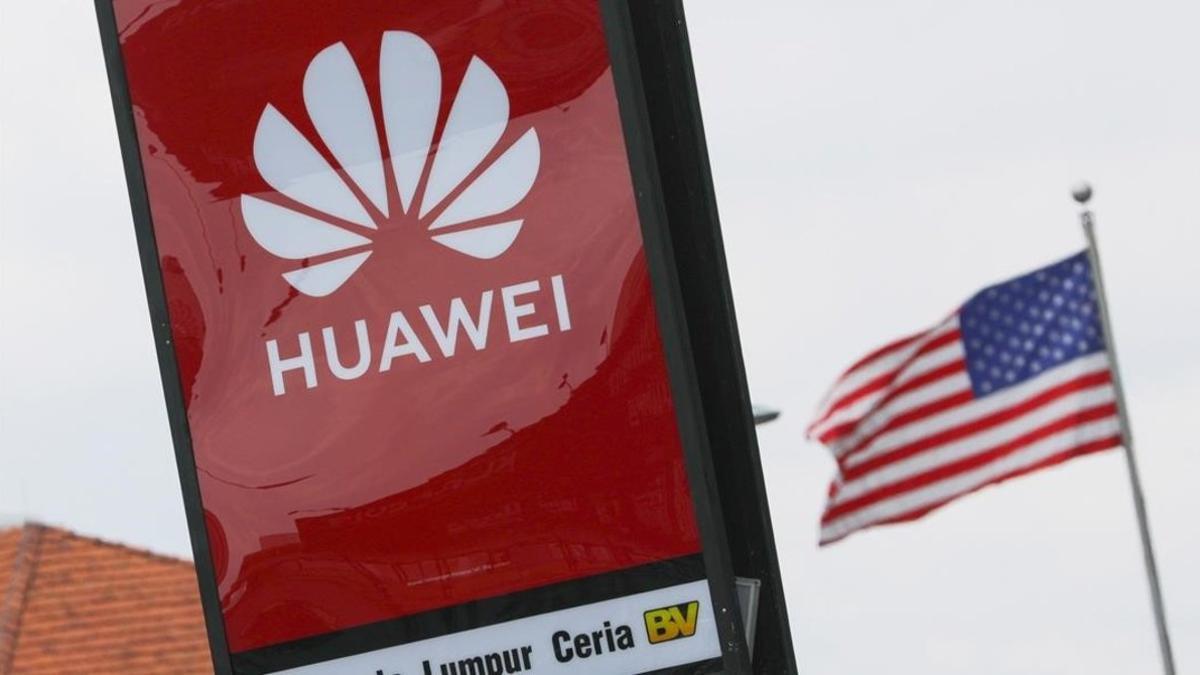 Logotipo de Huawei y la bandera de EEUU de fondo en Kuala Lumpur, Malasia.