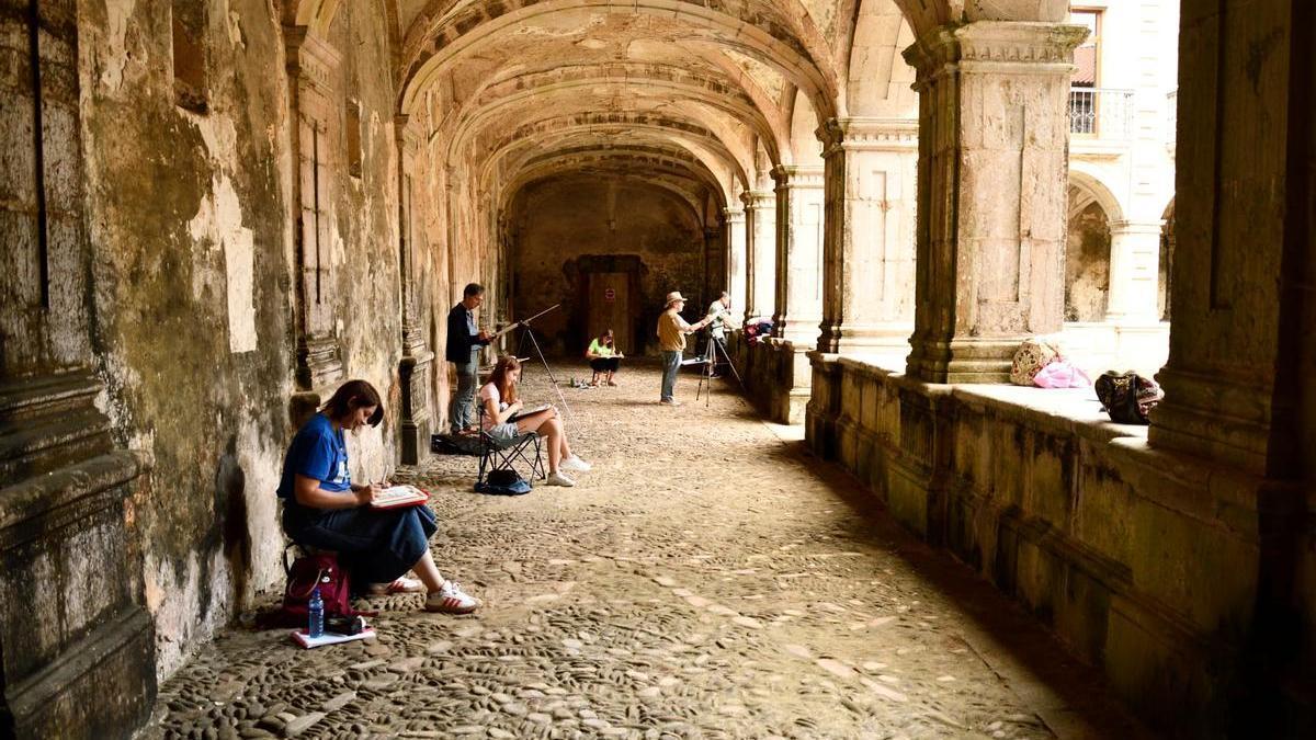 Participantes en el tercer encuentro de acuarela mientras realizan sus obras en el claustro del monasterio de Cornellana.