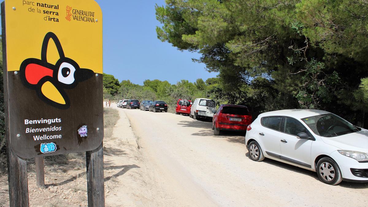 Coches aparcados en el acceso a la pista de la Sierra de Irta