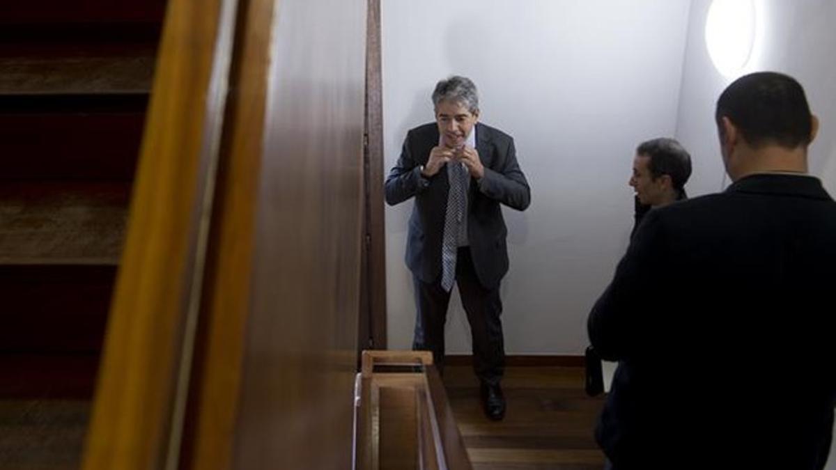 El candidato de Democràcia i Llibertat, Francesc Homs, rehace el nudo de su corbata bajo las escaleras antes de participar en la lectura del manifiesto 'Compromís amb Catalunya', en el Museu d'Història de Barcelona.