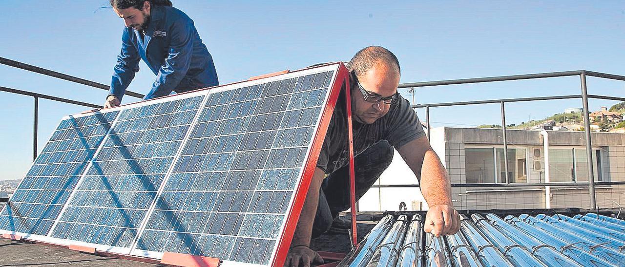 Dos operarios trabajan en el montaje de una instalación fotovoltaica, en una imagen de archivo.
