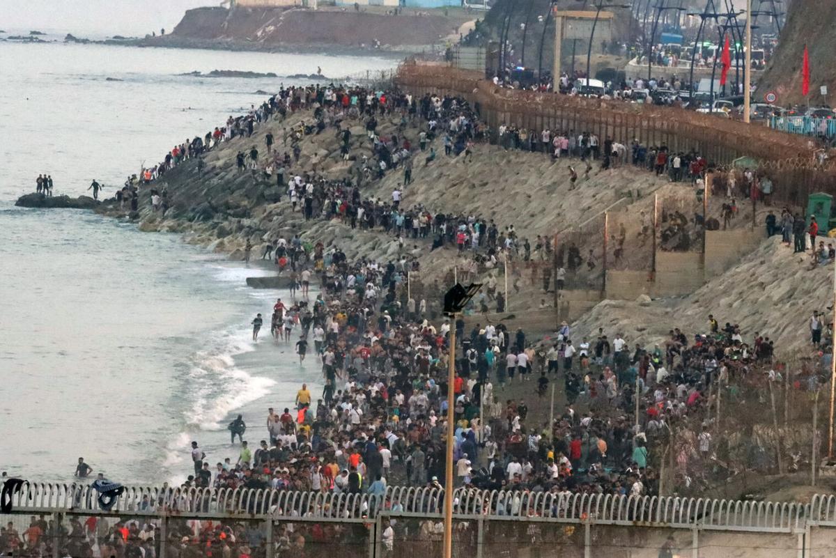 Multitud de personas se concentran en la parte marroquí de la playa del Tarajal para intentar acceder a Ceuta. EFE / Reduan