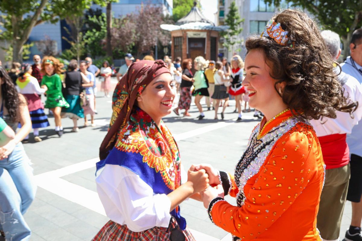 Una integrante de la Asociación de Coros y Danzas de badajoz baila con otra del grupo irlandés.