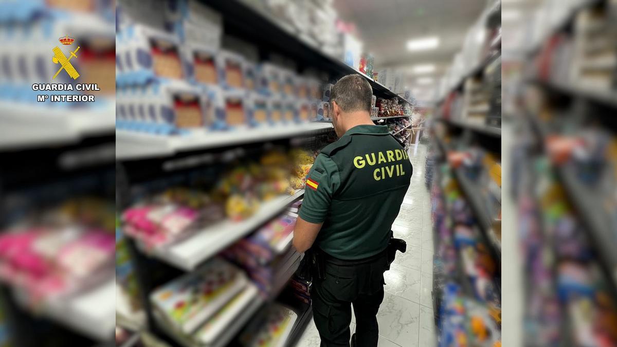 Un agente de la Guardia Civil ante varios de los juguetes falsificados