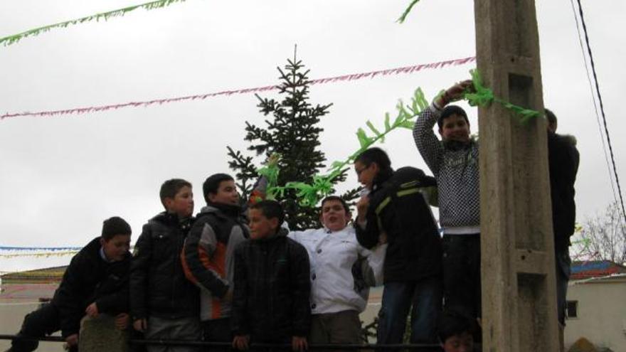 Un grupo de niños coloca banderines en las pasadas fiestas de Manganeses.