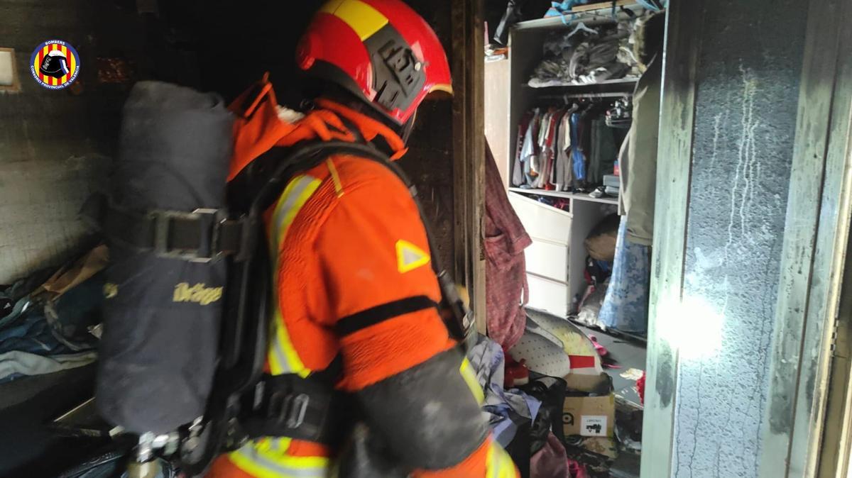 Un bombero accede al domicilio afectado por el incendio registrado hoy en Mislata.