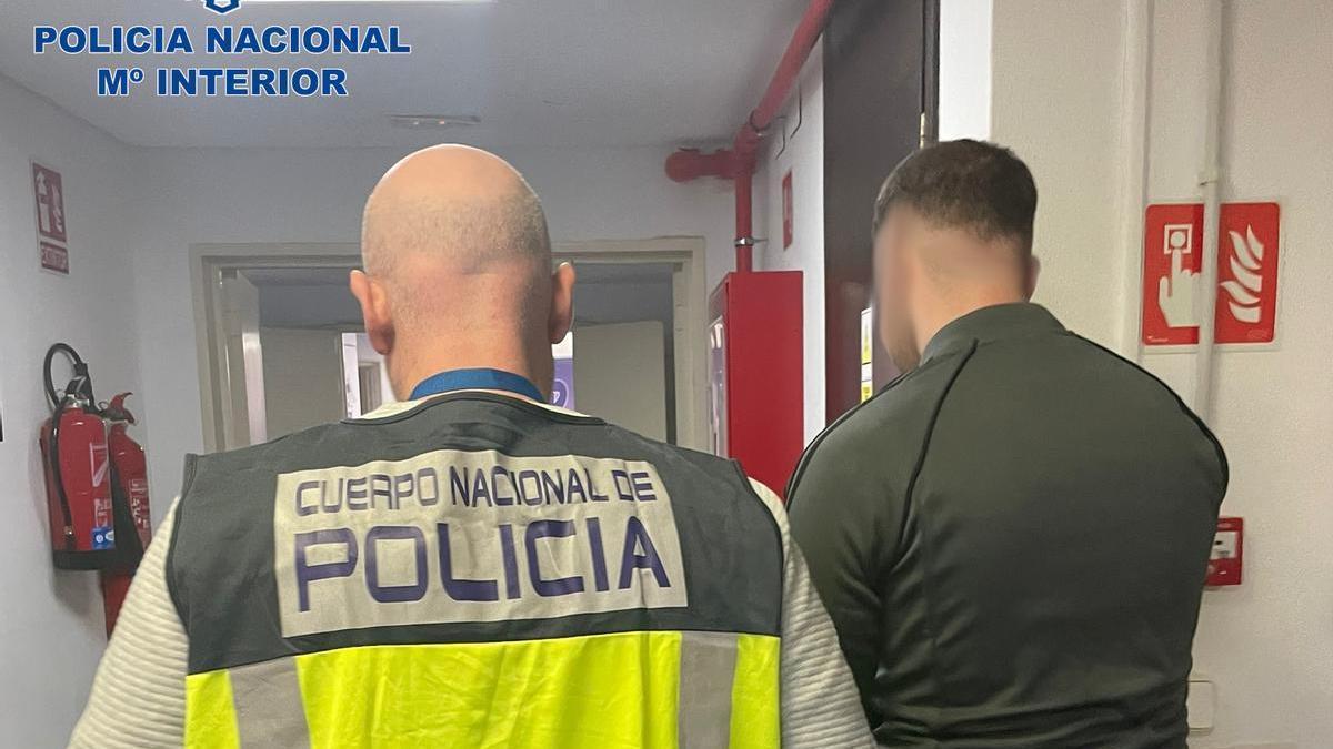 Un policía custodia a uno de los detenidos por el asalto.